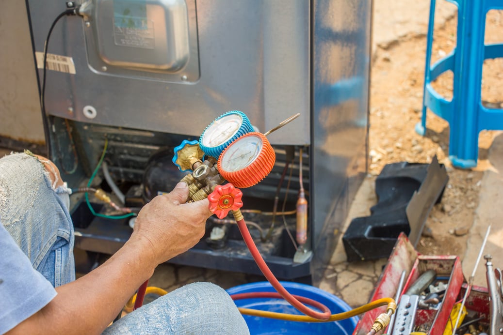 repair refrigerator job with pressure gauge , technician vacuum system refrigerator at maintenance shop.